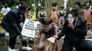 Mereka menyuarakan kritik terhadap ancaman deforestasi besar-besaran untuk Proyek Strategis Nasional (PSN) tebu di Merauke. Tampak dalam foto, aktivis Greenpeace Indonesia bersama beberapa pemuda Papua menggelar aksi teatrikal saat berunjuk rasa di depan Kantor Kementerian Koordinator bidang Perekonomian, Jakarta, Kamis (18/12/2025). (Yasuyoshi Chiba/AFP)