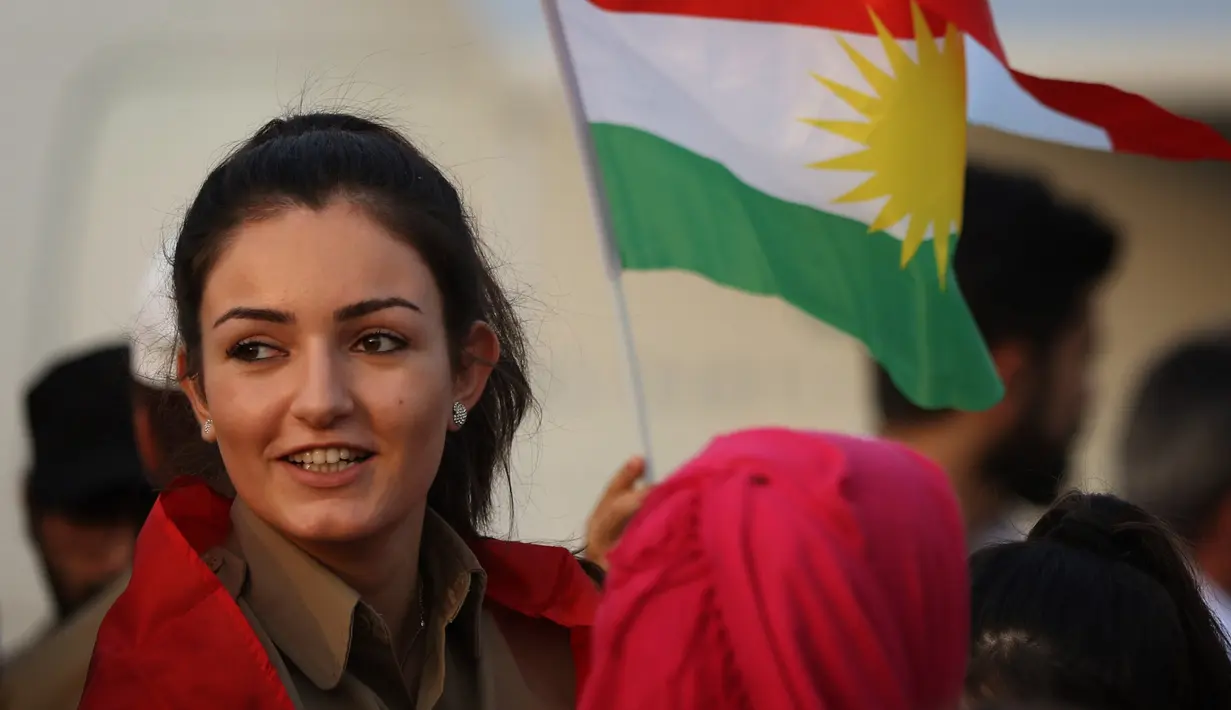 Seorang gadis Kurdi Iran memegang bendera Kurdi ikut mengampanyekan referendum untuk kemerdekaan di kota Bahirka, Irak Utara (21/9). Referendum tersebut mendapat pertentangan dari Negara tetangga Irak, yaitu Iran, Turki, dan Suriah.(AFP Photo/Safin Hamed)