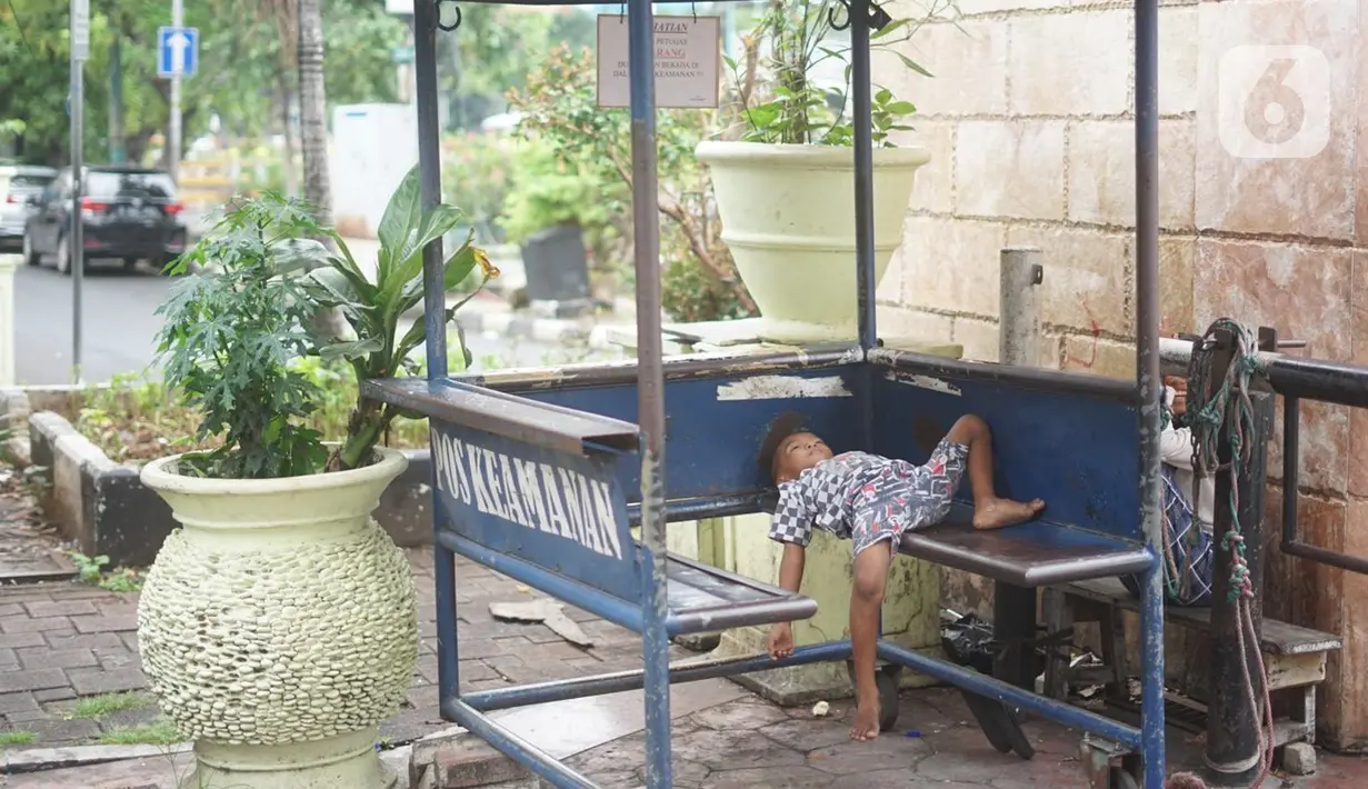 Seorang anak tidur di sebuah pos Pasar Baru, Jakarta Pusat, Senin (4/5/2020). Adanya program PSBB menyebabkan hampir seluruh pertokoan di salah satu pusat tekstil Ibukota tersebut berhenti beroperasi dan lebih sepi dibanding hari biasa. (Liputan6.com/Immanuel Antonius)