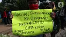 Seorang mahasiswa menunjukkan poster saat melakukan aksi unjuk rasa di sekitar kawasan Patung Kuda, Jalan Medan Merdeka Barat, Jakarta, Selasa (20/10/2020). Dalam aksinya, ratusan mahasiswa meminta pemerintah membatalkan pengesahan Omnibus Law UU Cipta Kerja. (Liputan6.com/Helmi Fithriansyah)