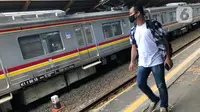 Calon penumpang melintasi rangkaian KRL Commuter Line di Stasiun Depok Baru, Jawa Barat, Senin (25/5/2020). Banyaknya warga yang silaturahmi selama lebaran menyebabkan perjalanan KRL tetap dipadati penumpang, meskipun waktu operasional dibatasi. (Liputan6.com/Immanuel Antonius)