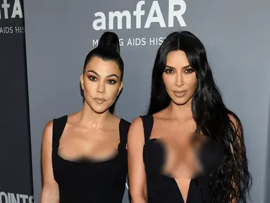 Kim Kardashian (kanan) dan Kourtney Kardashian berpose saat menghadiri Gala amfAR New York AIDS 2019 di Cipriani Wall Street, Rabu (6/2). (Photo by Evan Agostini/Invision/AP)
