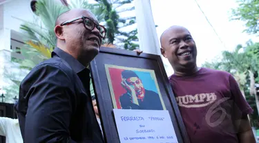 Pembawa acara dan penyanyi, Teuku Edwin dan Jody Sumantri memegang foto almarhum Ferrasta Soebardi alias Pepeng di rumah duka di kawasan Cinere, Depok, Rabu (6/5/2015). Pepeng meninggal dunia di usia 60 tahun. (Liputan6.com/Helmi Afandi)