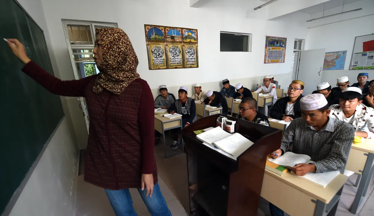 Seorang guru saat mengajar di kelas mahasiswa China Hui Muslim di Institut Islam di Yinchuan Ningxia, Provinsi Ningxia utara China (22/9/2015). Kampus ini memiliki slogan "Cinta negara, cinta agama" yang terpampang di pintu masuk. (AFP PHOTO/GOH CHAI HIN)