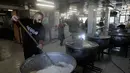 Para sukarelawan memasak makanan untuk para pengungsi yang menghindari serangan udara Israel di Lebanon selatan dan Dahiyeh, di Institut Teknik Bir Hassan yang telah diubah menjadi tempat penampungan, Beirut, Rabu 11 Maret 2026. Ratusan ribu warga Lebanon terpaksa mengungsi dari pinggiran selatan Beirut setelah peringatan evakuasi dan serangan udara Israel. (AP Photo/Bilal Hussein)
