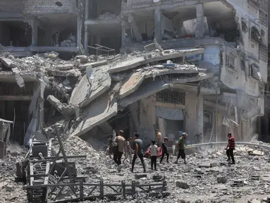 Warga Palestina mencari barang-barang yang dapat diselamatkan di reruntuhan bangunan yang hancur sehari sebelumnya dalam serangan Israel di lingkungan Al-Daraj, Kota Gaza pada 16 Juli 2025. (Omar AL-QATTAA/AFP)