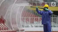 Petugas menyemprotkan cairan disinfektan ke bench pemain di Stadion Utama Gelora Bung Karno (SUGBK), Jakarta, Kamis (26/3/2020). Penyemprotan dilakukan guna mencegah penyebaran virus corona COVID-19 di seluruh venue kawasan SUGBK. (merdeka.com/Imam Buhori)