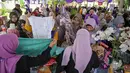 Masyarakat menerima barang-barang gratis seperti pakaian, bahan makanan pokok, dan perlengkapan rumah tangga yang disediakan oleh Asosiasi Organisasi Wanita (GOW) dan pemerintah daerah selama kegiatan aksi sosial tahunan di bulan Ramadan, Surabaya pada Senin 2 Maret 2026. (JUNI KRISWANTO/AFP)