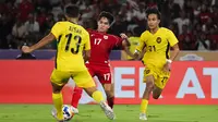 Pemain Timnas Indonesia U-23, Victor Dethan (tengah), berduel dengan dua pemain Malaysia U-23 pada laga pemungkas Grup A Piala AFF U-23 2025 di Stadion Utama Gelora Bung Karno (SUGBK), Senin (21/7/2025) malam WIB. (Bola.com/Abdul Aziz)