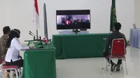 Salah seorang pedagang menghadap layar menjalani sidang yustisi secara virtual karena melanggar aturan PPKM Darurat. Sidang digelar di Gedung Mini Perkantoran Terpadu Pemkot Malang pada Senin, 19 Juli 2021 (Kominfo Kota Malang)alai Ko