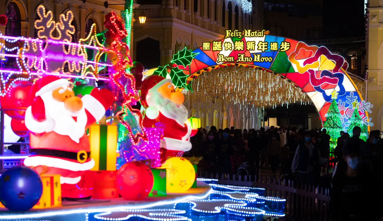 Karakter Sinterklas terlihat saat para wisatawan menyaksikan dekorasi Natal di Largo Do Senado, Makau, China, 22 Desember 2020. Largo do Senado atau Senado Square merupakan area perbelanjaan yang terkenal di Makau. (Xinhua/Cheong Kam Ka)