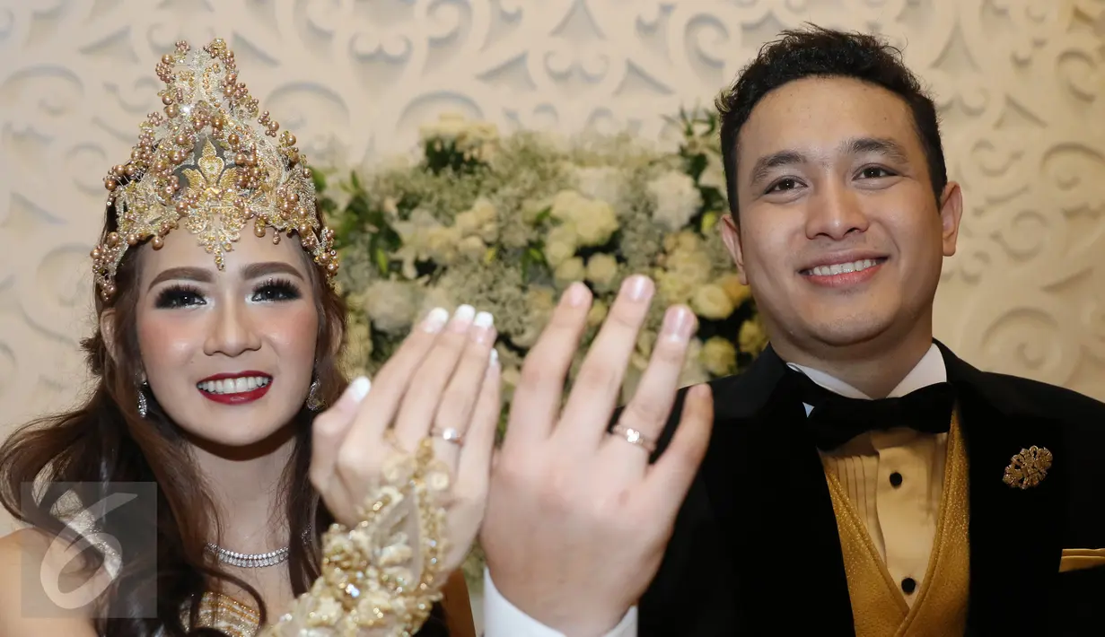 Gilang Dirga dan sang istri, Adiezty Fersa menunjukkan cicin nikah mereka saat jumpa pers di Kelapa Gading, Jakarta, Minggu (18/9). Akad nikah Gilang Dirga dan Adiezty digelar secara tertutup bagi media. (Liputan6.com/Herman Zakharia)