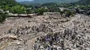 Pemandangan dari udara menunjukkan para korban banjir berkumpul di dekat rumah-rumah yang rusak di sepanjang tepi sungai yang dikelilingi batu-batu besar di distrik Buner, provinsi Khyber Pakhtunkhwa, Pakistan pada 17 Agustus 2025. (Abdul MAJEED/AFP)