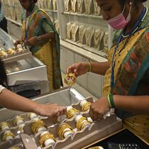 Seorang pelanggan (kiri) memeriksa gelang emas selama festival Hindu 'Akshaya Tritiya', hari keberuntungan dalam kalender Hindu untuk membeli barang-barang berharga, di ruang pamer perhiasan di Chennai, India, Selasa (3/5/2022). Membeli emas adalah kegiatan yang populer di Akshaya Tritiya, karena ini adalah simbol utama kekayaan dan kemakmuran. (Arun SANKAR / AFP)
