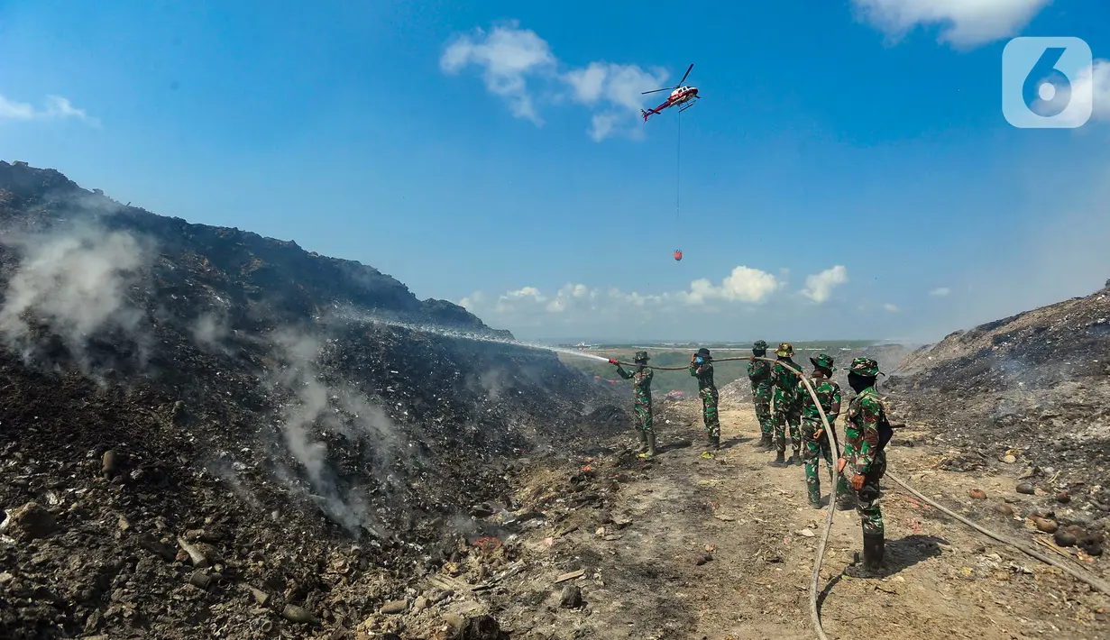 Anggota Raider 900/SBW TNI AD dan helikopter Badan Nasional Penanggulangan Bencana (BNPB) berupaya untuk memadamkan kebakaran sampah di Tempat Pembuangan Akhir (TPA) Regional Sarbagita Suwung, Denpasar, Bali, Jumat (20/10/2023). Hingga saat ini, kebakaran yang terjadi pada Kamis (12/10) tersebut belum dapat dipadamkan. (merdeka.com/Arie Basuki)