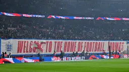 Pendukung Timnas Inggris membentangkan banner untuk menyambut debut Thomas Tuchel sebagai pelatih saat laga Kualifikasi Piala Dunia 2026 melawan Albania di Wembley Stadium, London, Jumat (21/03/2025) waktu setempat. (AFP/Glyn Kirk)