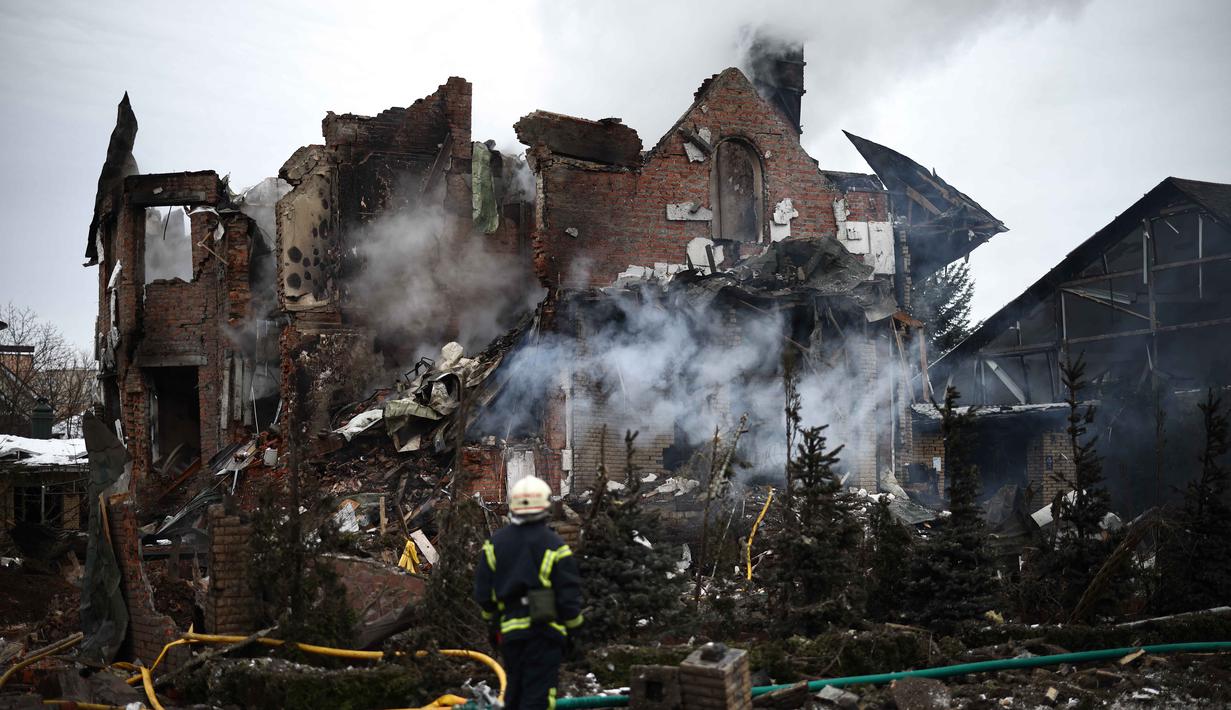 Konflik ini merupakan kelanjutan dari ketegangan yang bermula sejak aneksasi Krimea oleh Rusia pada tahun 2014. Tampak dalam foto, seorang petugas penyelamat Ukraina berdiri di samping sebuah rumah yang rusak parah setelah serangan udara di Sofiivska Borshchagivka, wilayah Kyiv pada Minggu 22 Februari 2026. (Henry NICHOLLS/AFP)