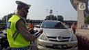 Polisi menghentikan mobil saat pemberlakuan ganjil genap di kawasan Fatmawati, Jakarta, Senin (25/10/2021). Pemberlakuan sistem ganjil genap di DKI Jakarta karena meningkatnya volume kendaraan di masa PPKM level 2. (Liputan6.com/Herman Zakharia)