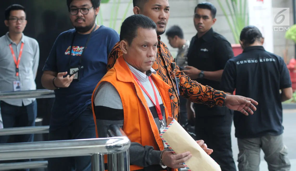 Staf PT Industri Telekomunikasi Indonesia (Inti) Taswin Nur menutupi borgol di tangannya dengan map cokelat saat akan melaksanakan salat, Gedung KPK, Jakarta, Jumat (16/8/2019). Nur diperiksa sebagai tersangka terkait aliran suap proyek pengadaan sistem penanganan bandara. (merdeka.com/Dwi Narwoko)