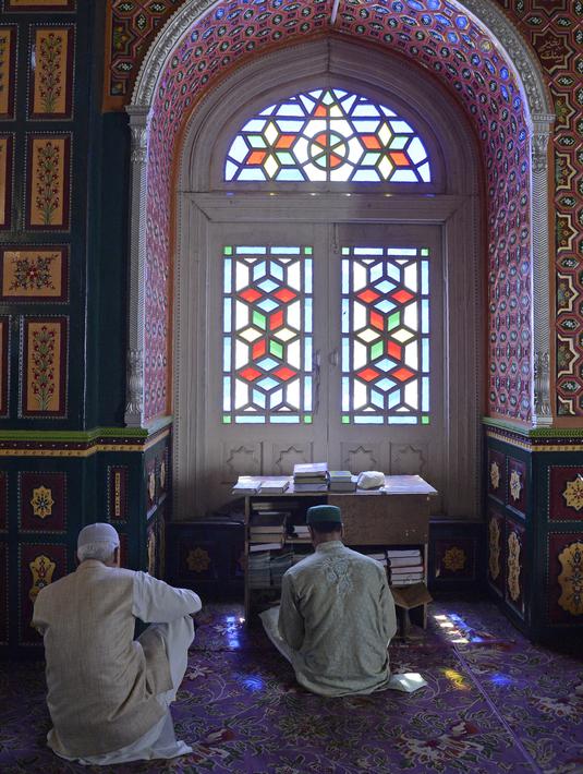 Muslim Kashmir membaca Alquran saat berada di masjid makam Syekh Abdul Qadir Jaelani pada bulan Ramadan di pusat kota Srinagar, Kashmir (24/5). (AFP/Tauseef Mustafa)