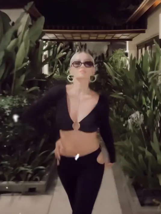 Ia pun tampil seksi dengan atasan crop top lengan panjang. Dipadukan celana panjang cut out. (@agnezmo)