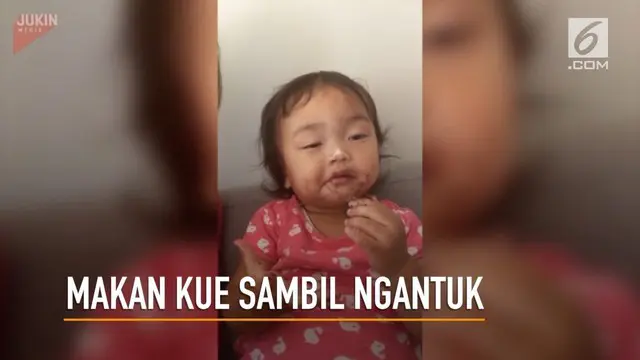 Seorang gadis kecil tetap menikmati kue yang diberikan ibunya walau sedang mengantuk berat.