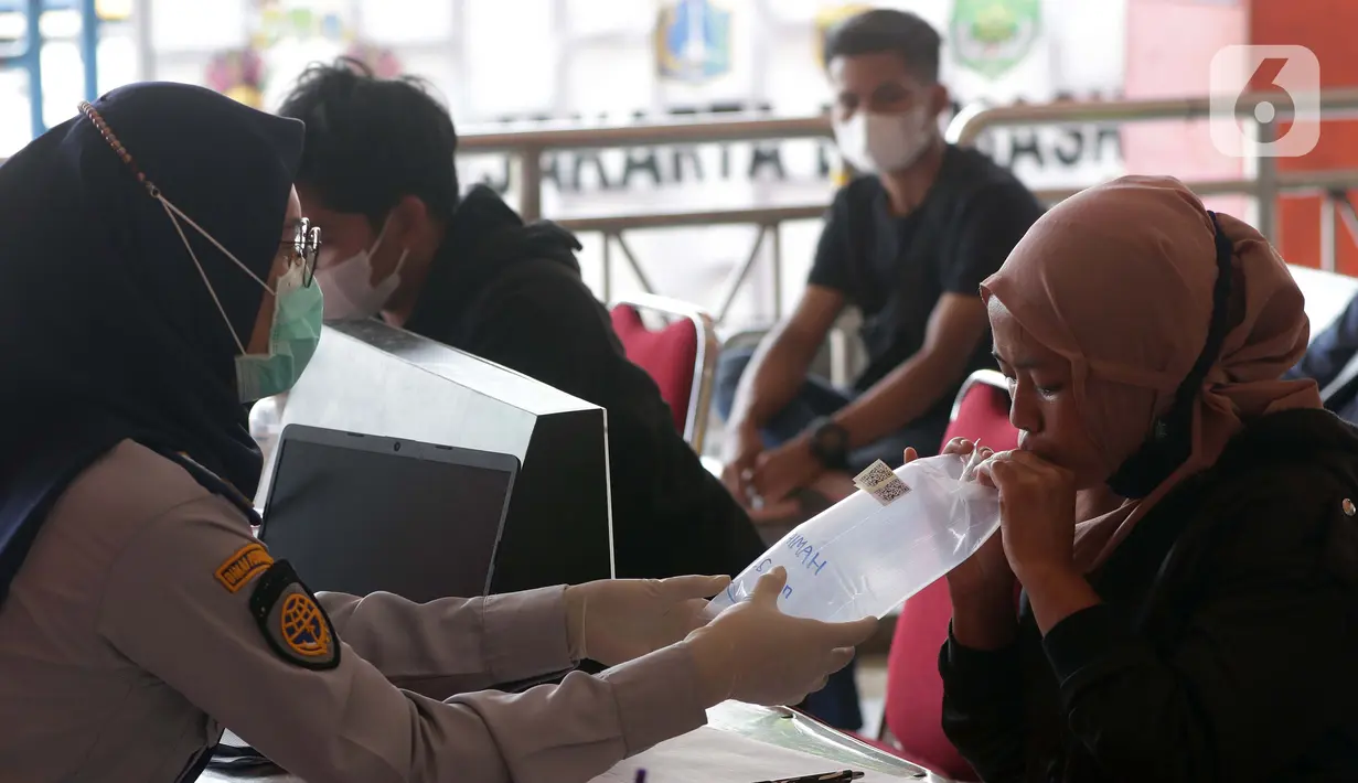 Warga menjalani test GeNose C19 di Terminal Bus Antar Kota Antar Provinsi Kampung Rambutan, Jakarta, Kamis (20/5/2021). Penumpang bus yang tiba maupun akan berangkat diwajibkan menjalani pengecekan bebas COVID-19 melalui rapid test antigen atau GeNose. (Liputan6.com/Helmi Fithriansyah)