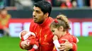 Striker Liverpool Luis Suarez membawa kedua putrinya menjelang pertandingan sepak bola Liga Inggris antara Liverpool vs Crystal Palace di stadion Anfield (05/10/13). (AFP/Paul Ellis)