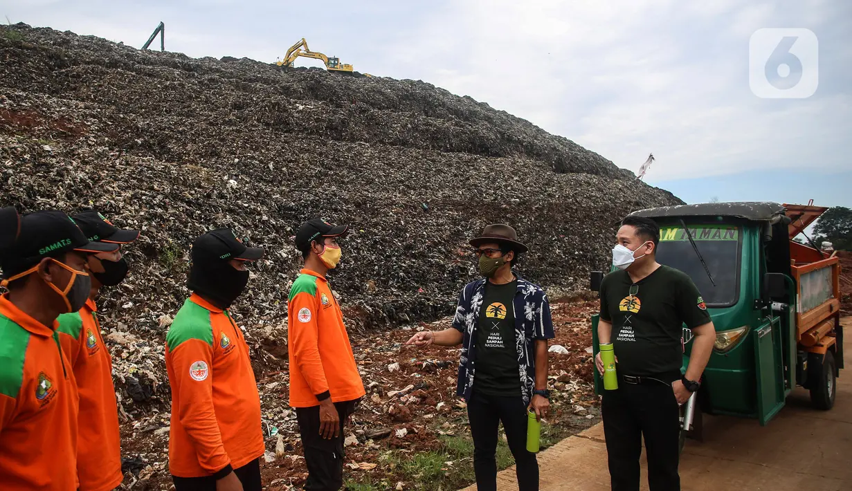 Direktur PT Bima Karya Prima Jeffry Riadi (kanan) dan Musisi serta Penggiat Lingkungan Hidup Nugie (kedua kanan) berbincang dengan pasukan orange saat peringatan Hari Sampah Nasional di TPST Bantar Gebang, Bekasi, Senin (21/2/2022). (Liputan6.com/JohanTallo)