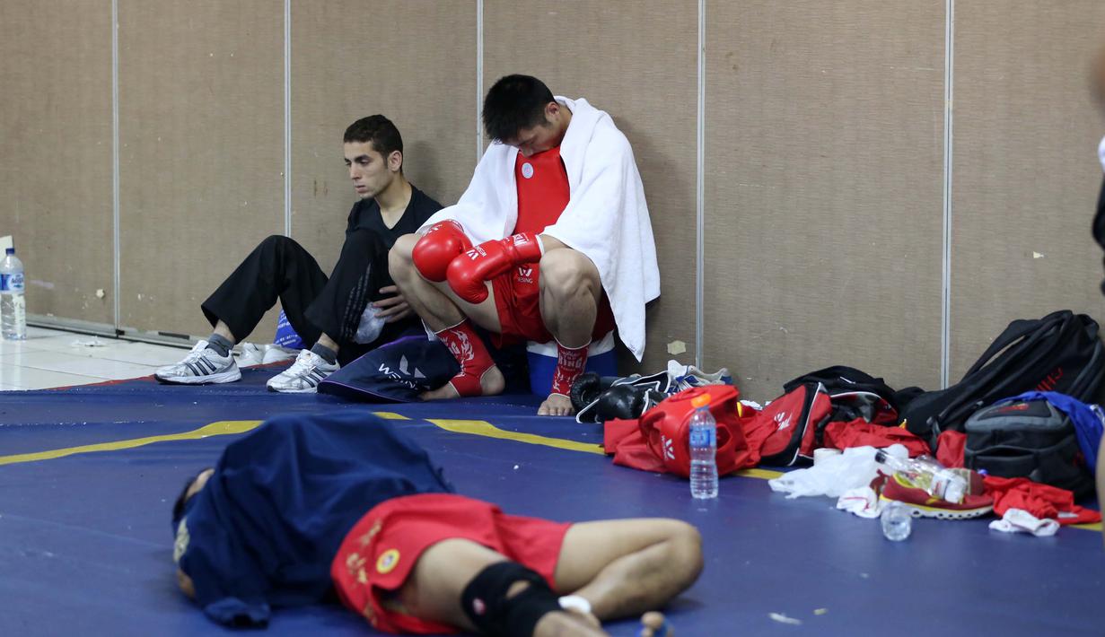 Atlet Wushu Asal China, bersantai sejenak sebelum bertanding pada Cabang Sanda Kejuaraan Dunia Wushu 2015 di Istora, Senayan, Jakarta,Rabu (18/11/2015). (Bola.com/Nicklas Hanoatubun)