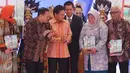 Gubernur BI Agus D.W. Martowardojo (kedua kiri) membagikan buku Laporan Perekonomian tahun 2016 kepada sejumlah undangan di Gedung BI, Jakarta, Kamis (27/4). (Liputan6.com/Angga Yuniar)