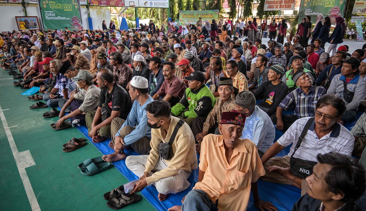 Tahun ini, total zakat yang didistribusikan mencapai Rp16 miliar, meningkat dua kali lipat dibanding tahun sebelumnya. Tampak dalam foto, warga mengantre untuk menerima bantuan uang tunai di masjid Cheng Hoo, Surabaya, Jawa Timur pada Rabu 4 Maret 2026. (JUNI KRISWANTO/AFP)