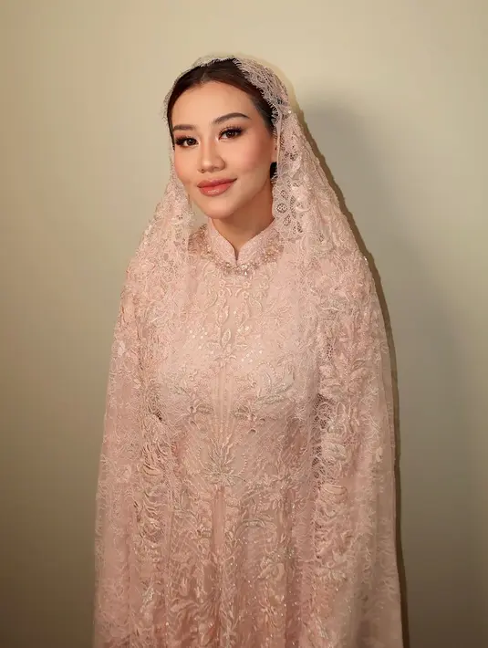 Aaliyah Massaid memilih busana lace bernuansa merah muda yang serasi dengan keseluruhan penampilannya. [Foto: Instagram/leoafandi_]