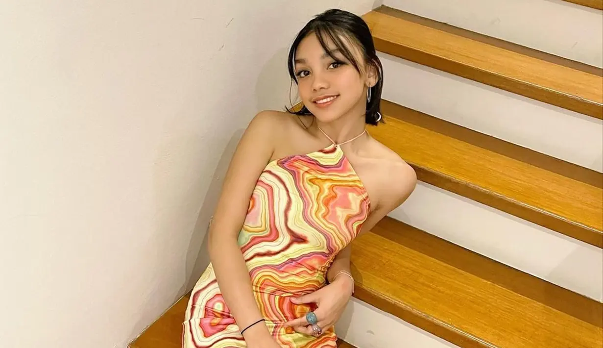 Bersuara merdu dan bisa berakting menjadi nilai plus untuk Naura Ayu dalam melebarkan sayapnya di dunia hiburan. Meski menggunakan riasan natural, wajahnya tetap manis dengan senyum lebar. Berpose di tangga dengan balutan outfit colorful membuat penampilannya semakin nyentrik. (Liputan6.com/IG/@naura.ayu)