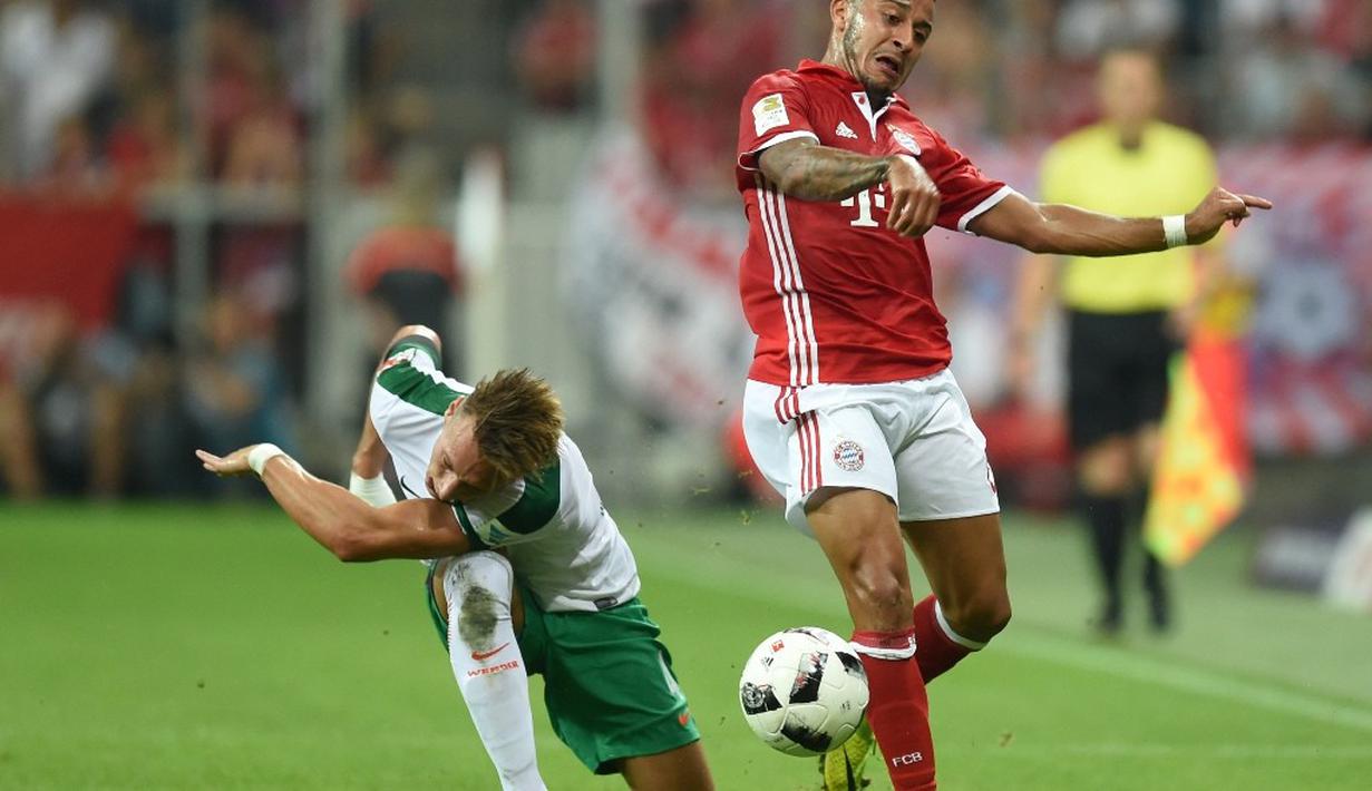 Pemain Bayern Munchen, Thiago Alcantara (kanan), berebut bola dengan pemain Werder Bremen, Robert Bauer, dalam laga Bundesliga di Allianz Arena, Munchen, Sabtu (27/8/2016) dini hari WIB. (AFP/Christof Stache)