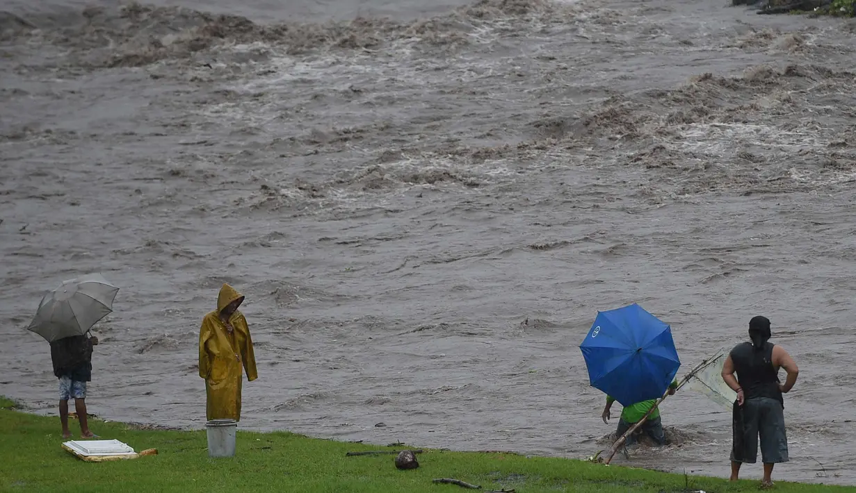 Warga Filipina menggunakan jaring mengambil material lahar dingin Gunung Mayon di sepanjang sungai di kota Daraga, provinsi Albay, Manila (27/1). Akibat hujan deras, jutaan ton abu dan batu dari gunung mayon mengalir kesungai. (AFP Photo/Ted Aljibe)