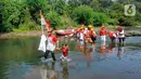 Usai upacara, peserta membersihkan sampah di Kali Ciliwung sambil membawa bendera Merah Putih. (merdeka.com/Arie Basuki)