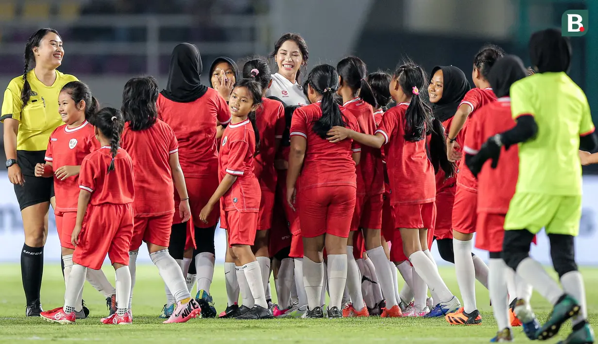 Ada yang menarik dalam rangkaian acara pentupan turnamen pramusim Piala Presiden 2024 di Stadion Manahan, Solo, Minggu (4/8/2024). Laga eksibisi antara 6 pemain Timnas Indonesia putri menghadapi 30 pemain SSB putri Surakarta FC U-12 digelar. Dalam laga yang hanya berlangsung kurang dari 10 menit tersebut, kapten Timnas Putri Indonesia, Shafira Ika menjadi magnet lewat aksi-aksinya hingga menjadi idola tim lawan. Bahkan saat mencetak gol, Ika langsung dikerumuni para pemain lawan untuk ikutan berselebrasi. (Bola.com/Bagaskara Lazuardi)