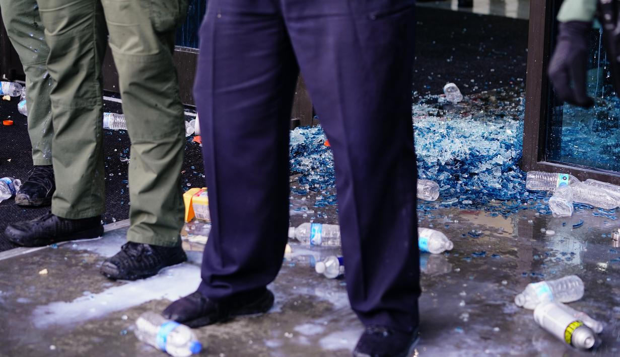 Aparat kepolisian melakukan penjagaan saat aksi protes di kantor pusat CNN di Atlanta, Georgia, Jumat (29/5/2020). Massa yang mengecam kematian George Floyd (46) oleh polisi melakukan vandalisme dan perusakan gedung CNN pusat. (Elijah Nouvelage/Getty Images/AFP)