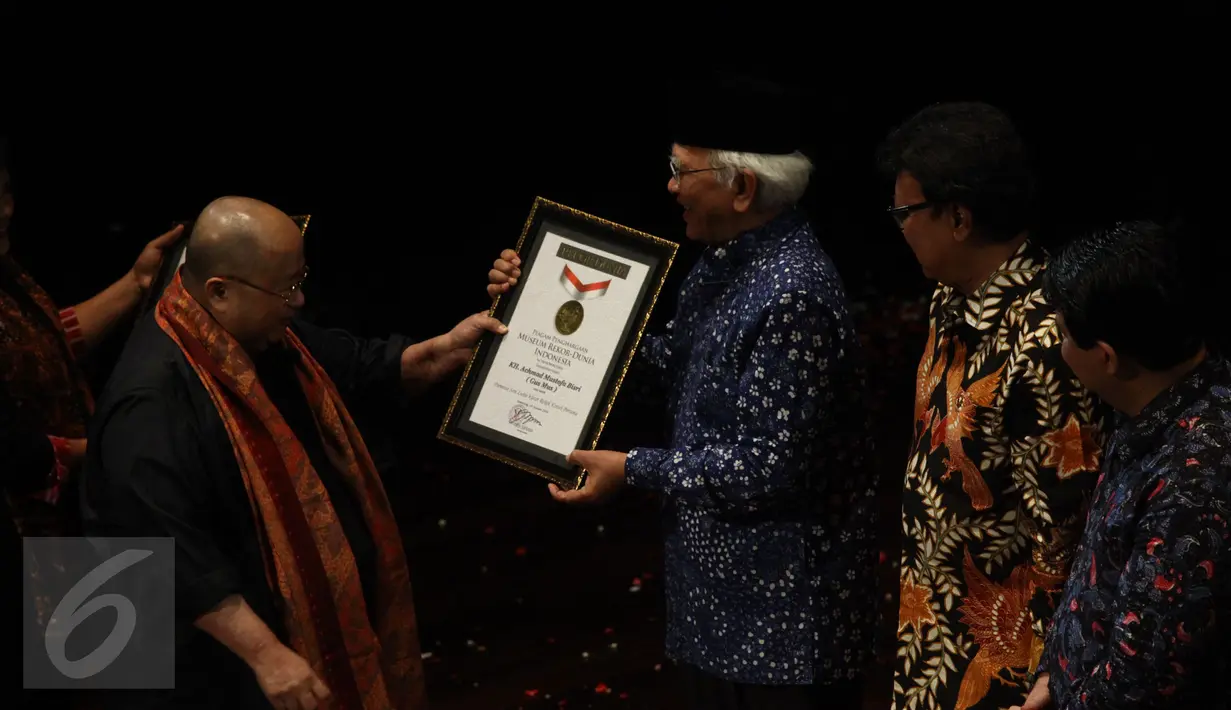 Jaya Suprana (kiri) memberikan penghargaan kepada Gus Mus saat HUT MURI ke 26, Jakarta, Kamis (28/1/2016). Gus Mus membuat rekor sebagai seniman seni lukis klelet rokok kretek pertama yang membuat pameran di galeri nasional. (Liputan6.com/Yoppy Renato)