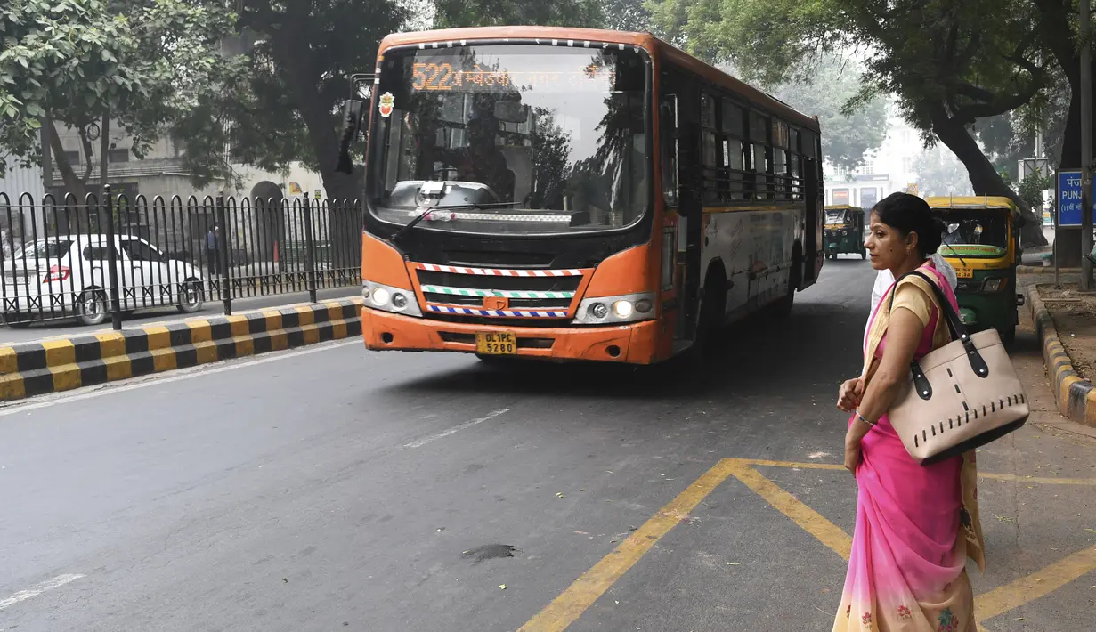 Seorang perempuan menunggu bus  New Delhi Transport Corporation untuk melakukan perjalanan gratis di New Delhi, 29 Oktober 2019. Program bus gratis bagi perempuan itu disebut sebagai langkah bersejarah untuk keselamatan dan meningkatkan peran mereka dalam perekonomian ibu kota. (Sajjad HUSSAIN/AFP)