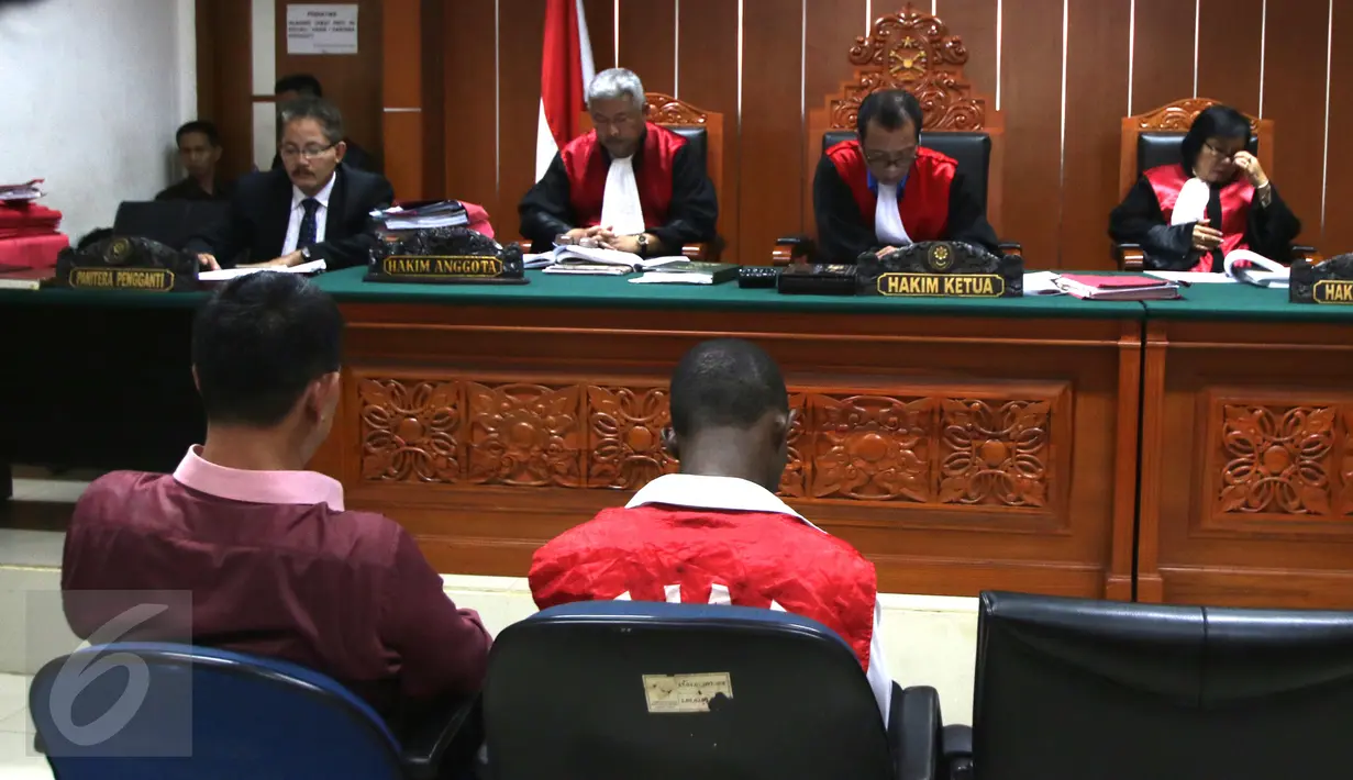 Warga negara Nigeria, Arinze Petrus Eneh (kiri) saat berkonsultasi dengan kuasa hukumnya saat sidang di PN Jakarta Barat, Jakarta, (18/5). Arinze Petrus Eneh ditangkap dalam  kasus narkotika sabu seberat 6,3 kg. (Liputan6.com/Helmi Afandi)
