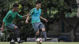 Pemain Timnas Indonesia, Muhammad Iqbal, berusaha melewati Bagas Adi saat latihan di Lapangan ABC Senayan, Jakarta, Jumat (19/1/2018). Pemusatan latihan ini dilakukan jelang Asian Games 2018. (Bola.com/Vitalis Yogi Trisna)