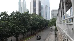 Sejumlah kendaraan melewati Jalan Sudirman, Jakarta, Jumat (3/4/2015).  Kondisi jalanan lengang disebabkan libur panjang yang bertepatan libur paskah dan banyaknya masyarakat Jakarta yang berlibur ke luar kota. (Liputan6.com/Herman Zakharia)