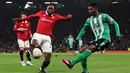Bek Manchester United atau MU, Aaron Wan-Bissaka (kedua kiri) berebut bola dengan bek Real Betis, Abner Vinicius pada leg pertama 16 besar Liga Eropa 2022/2023 di Old Trafford, Jumat dini hari WIB (10/3/2023). MU masih harus menjalani laga leg kedua di kandang Betis pada pekan depan. (Photo by Darren Staples / AFP)