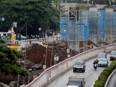 Kendaraan melintas disamping pembangunan proyek kereta ringan LRT di Jalan HR Rasuna Said, Kuningan, Jakarta, Rabu (20/12). Proyek yang saat ini dalam proses pemasangan tiang tersebut ditargetkan selesai Desember 2018. (Liputan6.com/Faizal Fanani)