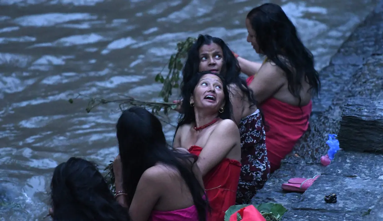 Wanita Hindu Nepal usai mandi suci di sungai Bagmati selama festival Rishi Panchami di Kathmandu (3/9/2019). Dalam festival Rishi Panchami, wanita yang belum menikah menginginkan suami yang tampan dan menikah dengan bahagia. (AFP Photo/Prakash Mathema)