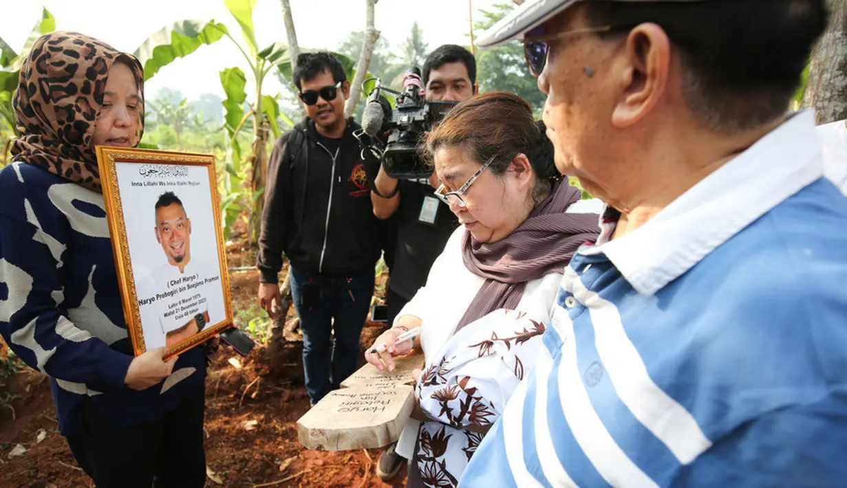 Seorang perempuan menulis papan keterangan yang akan ditancapkan di atas pusara pria yang sempat menjalani operasi jantung Diseksi Aorta pada tahun 2021 di RS Jantung Harapan Kita. [Foto: KapanLagi.com®/Bayu Herdianto]