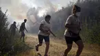 Orang-orang berlari untuk menyelamatkan diri dari api kebakaran hutan di dekat desa Melon, Spanyol barat laut, pada 17 Agustus 2025. (MIGUEL RIOPA/AFP)