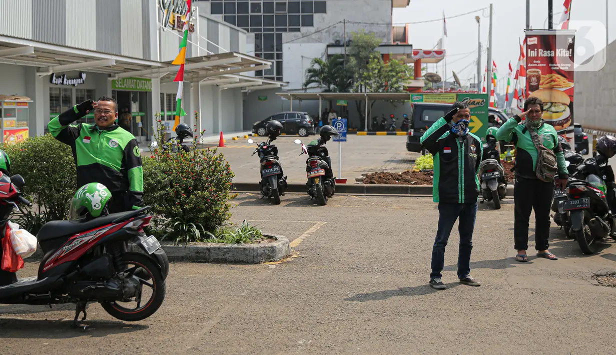 Pengemudi ojek online (ojol) mengambil sikap sempurna saat prosesi mengheningkan cipta di Kawasan Jalan RE Martadinata, Tangerang Selatan, Senin (17/8/2020). Kegiatan mengheningkan cipta ini dilakukan selama 3 menit dalam rangka memperingati HUT ke-75 RI. (Liputan6.com/Faizal Fanani)